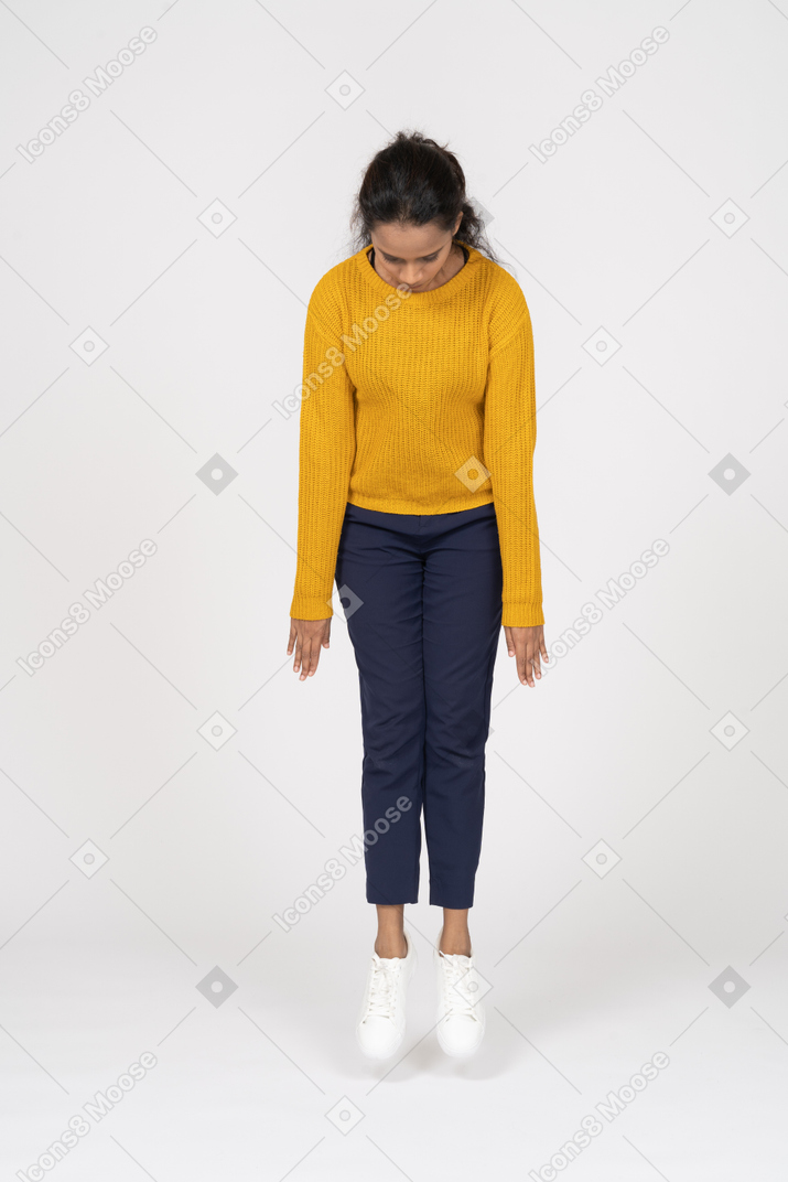 Vista frontal de uma garota com roupas casuais pulando