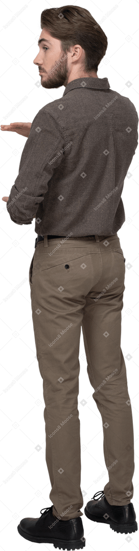 Трехчетвертный вид сзади молодого человека в офисной одежде, показывающего размер чего-то