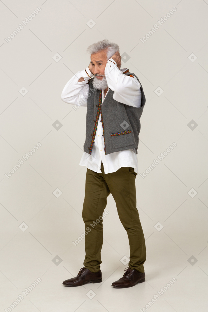 Homem com roupas casuais cobrindo os ouvidos