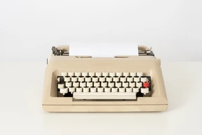 Beige typewriter on a white background