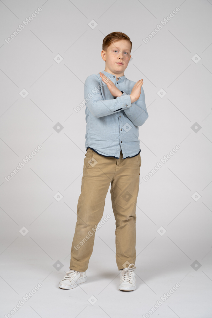 Vista frontal de um menino fazendo gesto de parada