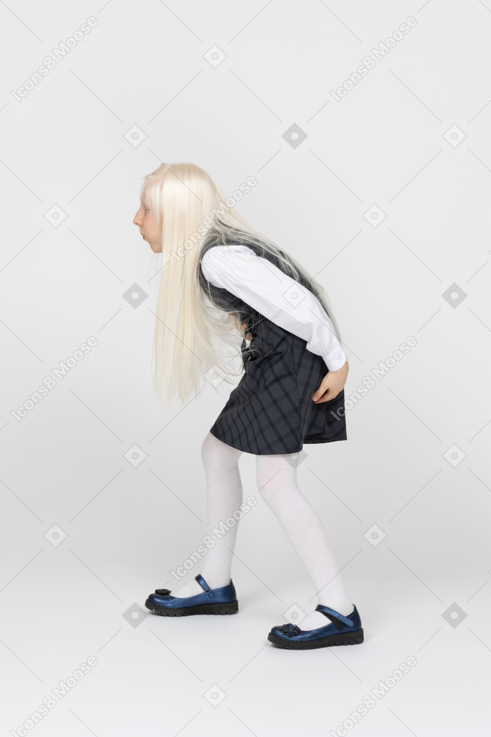 Side view of a schoolgirl bending forward