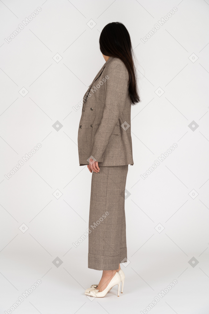 Вид сбоку молодой леди в коричневом деловом костюме, отворачивающейся