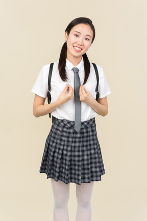 Asian school girl holding fists almost closed