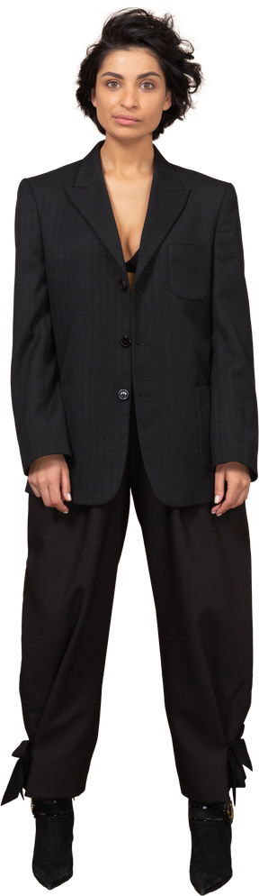 Vista frontal de una empresaria sonriente en un traje negro mirando a la cámara