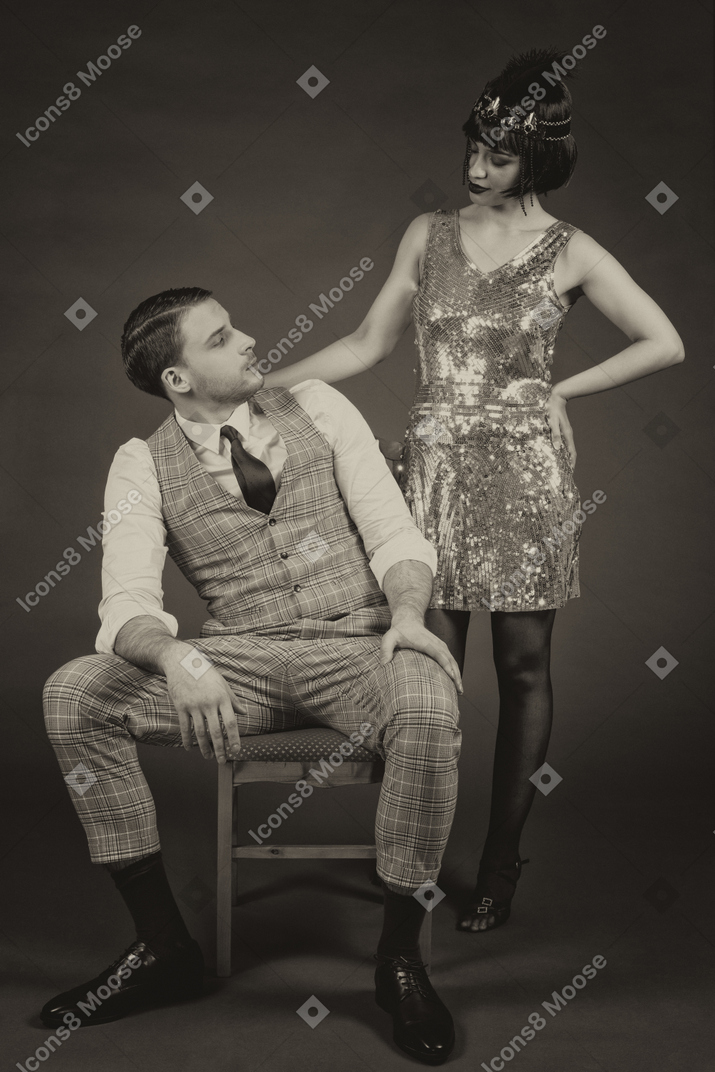 A well-dressed flapper and a gentleman looking at each other