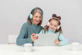 Grand-mère et petite-fille à l'aide de tablette numérique ensemble