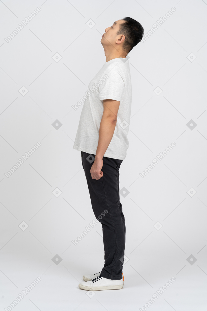 Side view of a man in casual clothes looking up