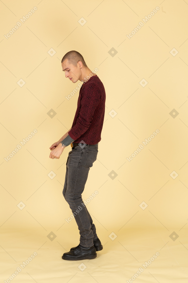 赤いプルオーバーで踊っている若い男の側面図