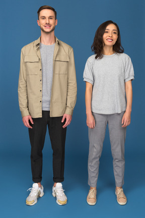 Young man and woman standing and looking at camera