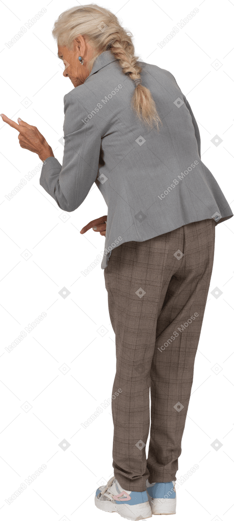 Rear view of an old lady in suit bending down and showing warning sign