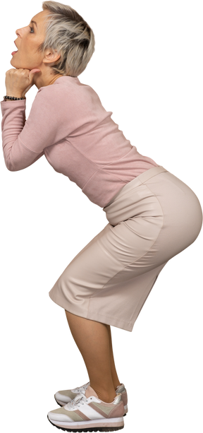 Vista lateral de uma mulher emocional em roupas casuais agachada