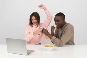 Casal atraente, assistindo a um jogo de esportes e bebendo cerveja