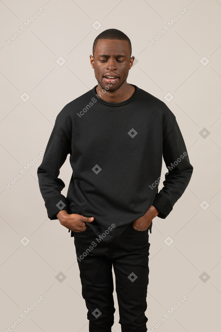 Man holding his hands in pockets and looking down