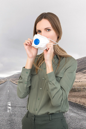 Woman in face mask standing on the road