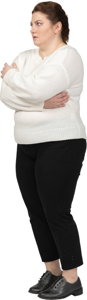 Plus size woman in casual clothes standing in profile with arms crossed
