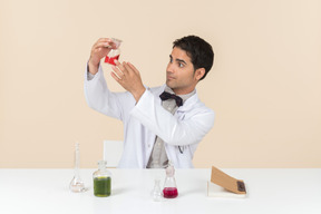 Scienziato maschio seduto al tavolo e guardando il tavolo