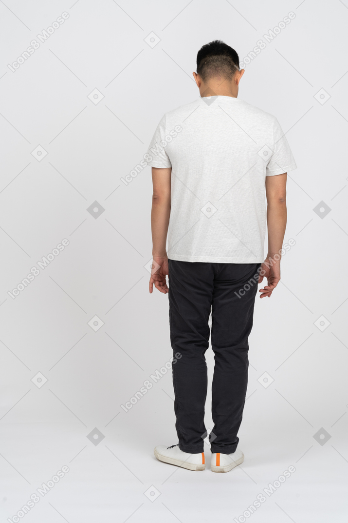 Vista traseira de um homem em roupas casuais em pé com a cabeça abaixada