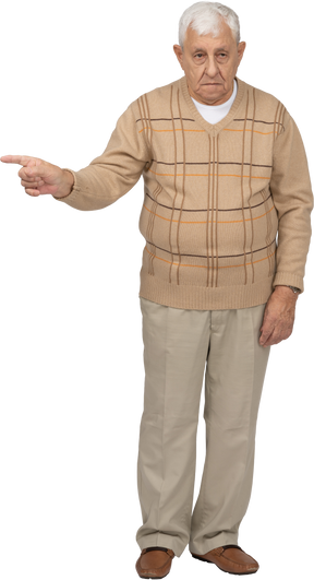 Front view of an old man in casual clothes pointing with finger