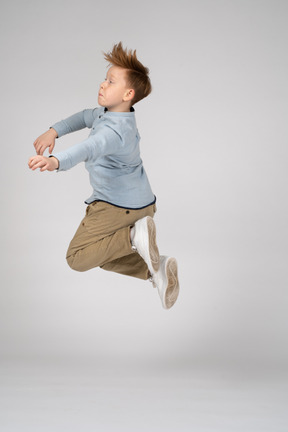 Side view of a boy jumping high in the air