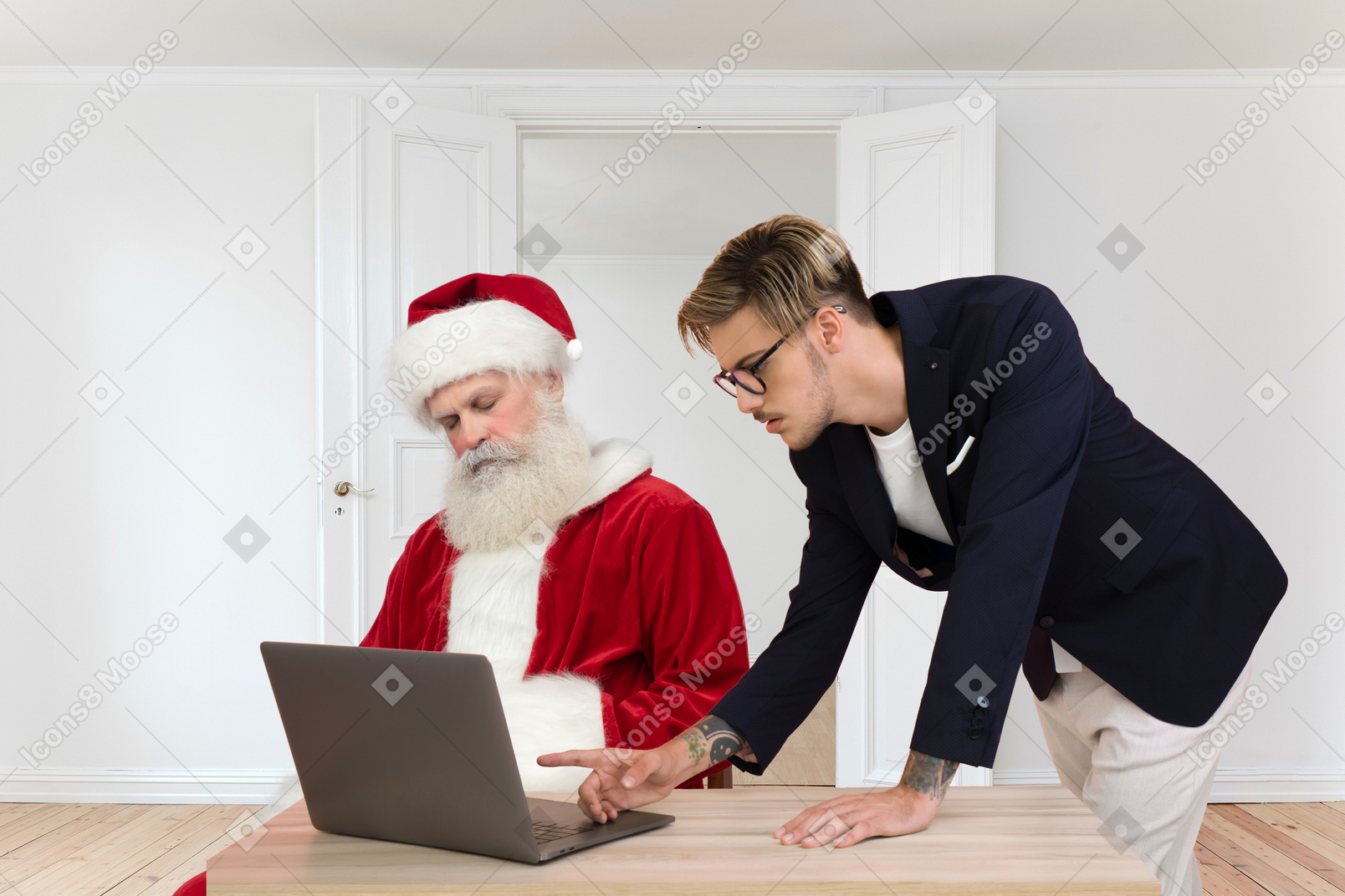 Santa döst, während ein junger mann einige informationen auf einem computer überprüft