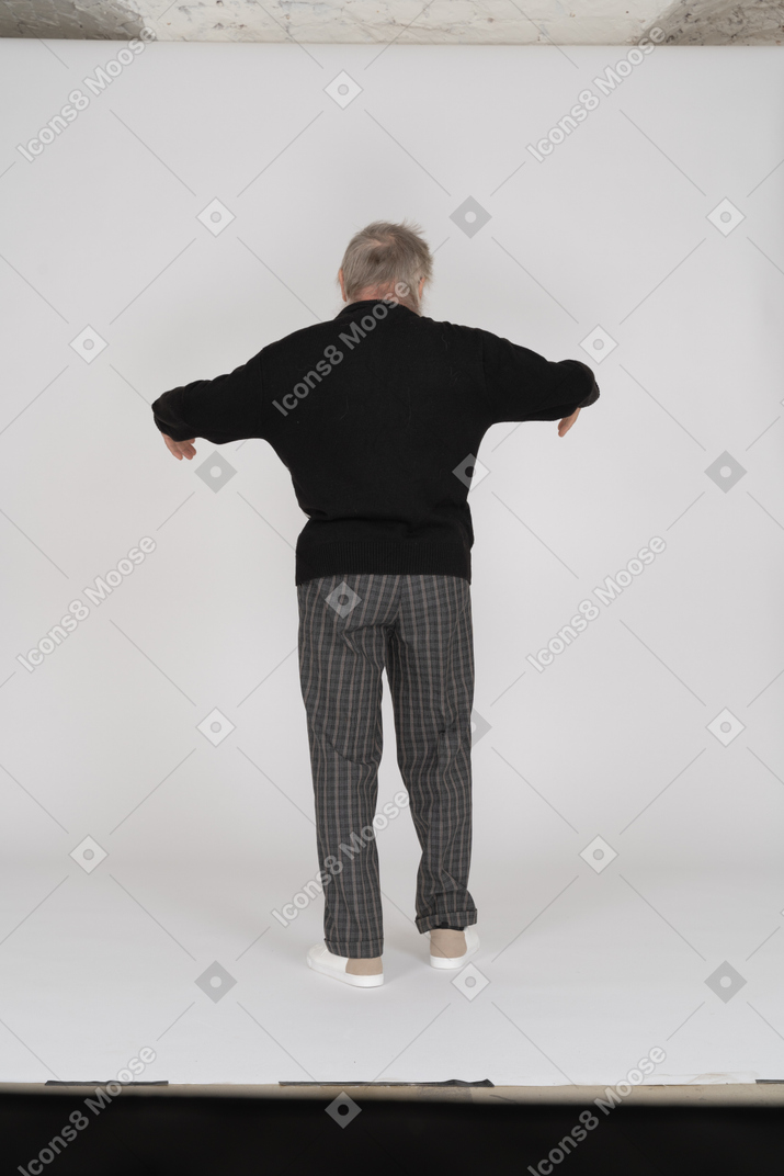 Rear view of old man standing with bent arms