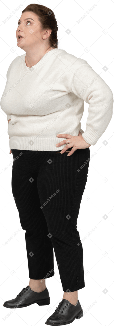Side view of a plump woman in casual clothes standing with hands on hips