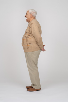 Side view of an old man in casual clothes shouting