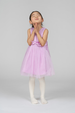 Niña en vestido rosa con los brazos cruzados