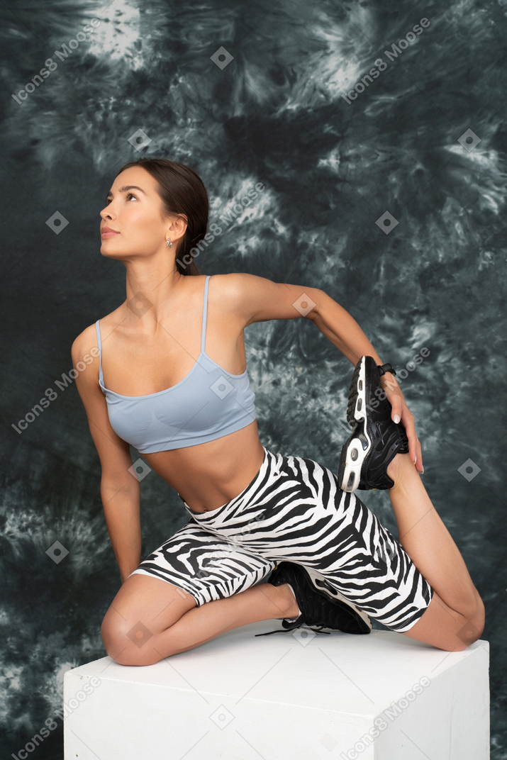 Atleta feminina esticando os quadris e olhando para cima
