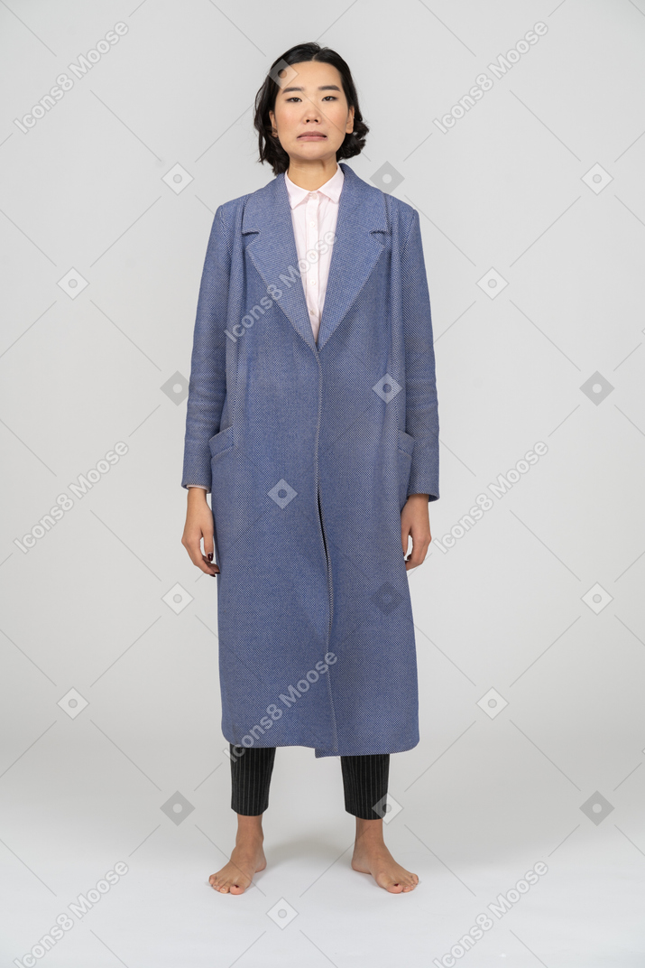 Vue de face d'une femme malheureuse en manteau bleu