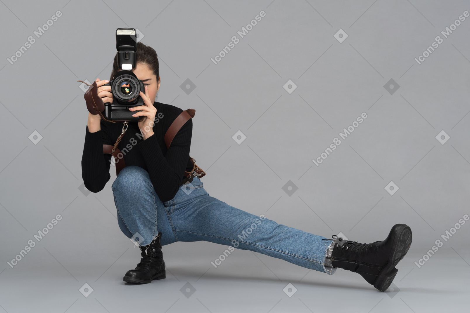 Female photographer taking pictures while sitting on one leg