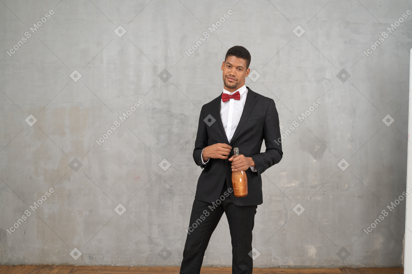 Man holding a champagne bottle and looking at camera
