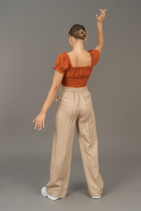 Back view of young woman pretending to throw someyhing