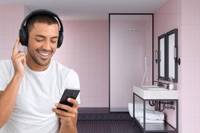 A man wearing headphones and using a cell phone