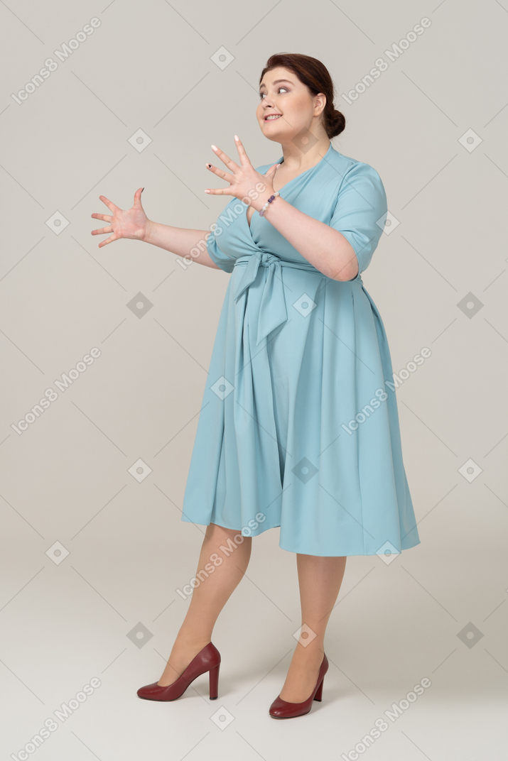 青いドレスジェスチャーで幸せな女性の正面図
