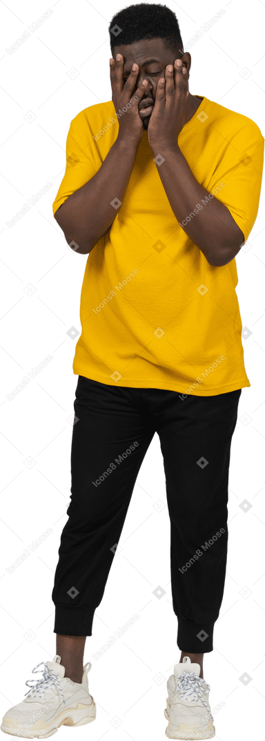 一个穿着黄色 t 恤、摸着脸、疲惫不堪的黑皮肤年轻男子的前视图