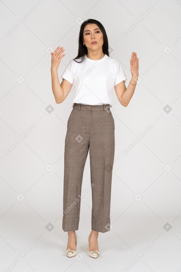Front view of a gesticulating young lady in breeches and t-shirt explaining something