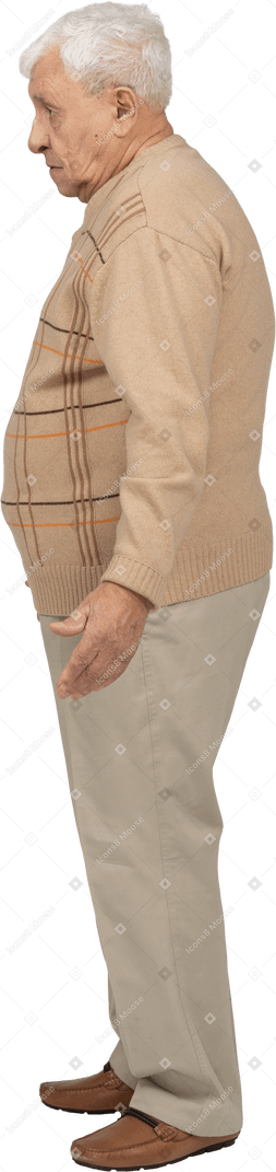 Side view of an old man in casual clothes standing with outstretched arms