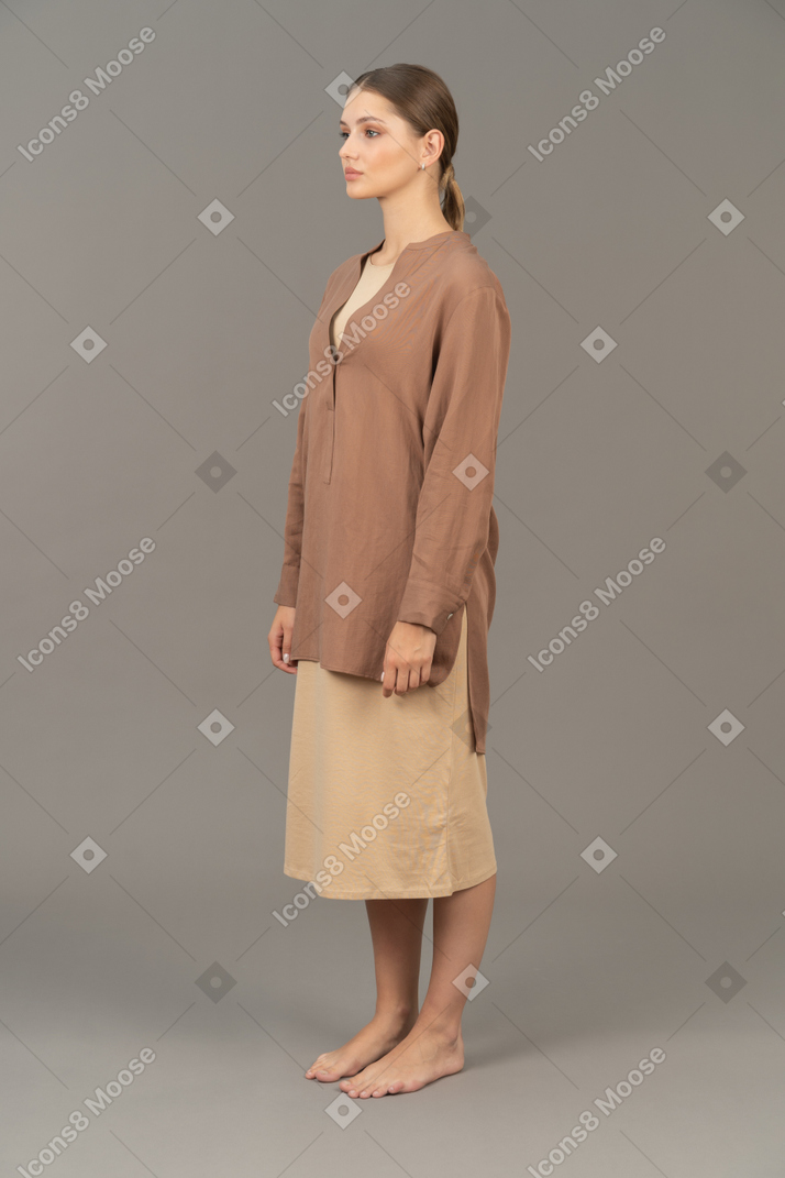 Вид в три четверти на молодую женщину, стоящую босиком