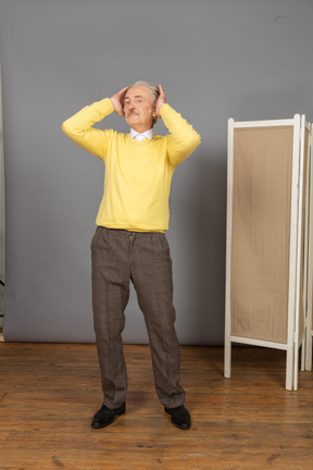 Front view of a confident old man adjusting his hair