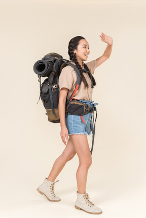 Female asian hiker shielding eyes from sun