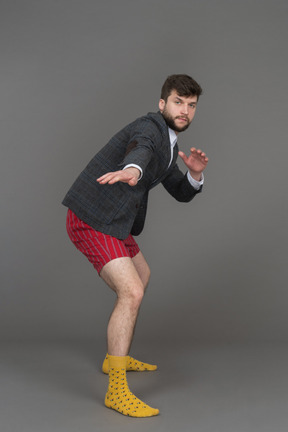 Hombre en shorts rojos y chaqueta gris practicando artes marciales