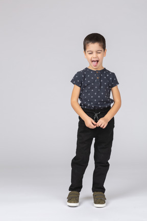 Vista frontal de um menino fofo mostrando a língua