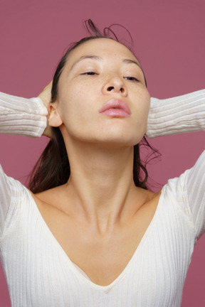 Close-up of a middle-aged female raising arms and making a hairstyle