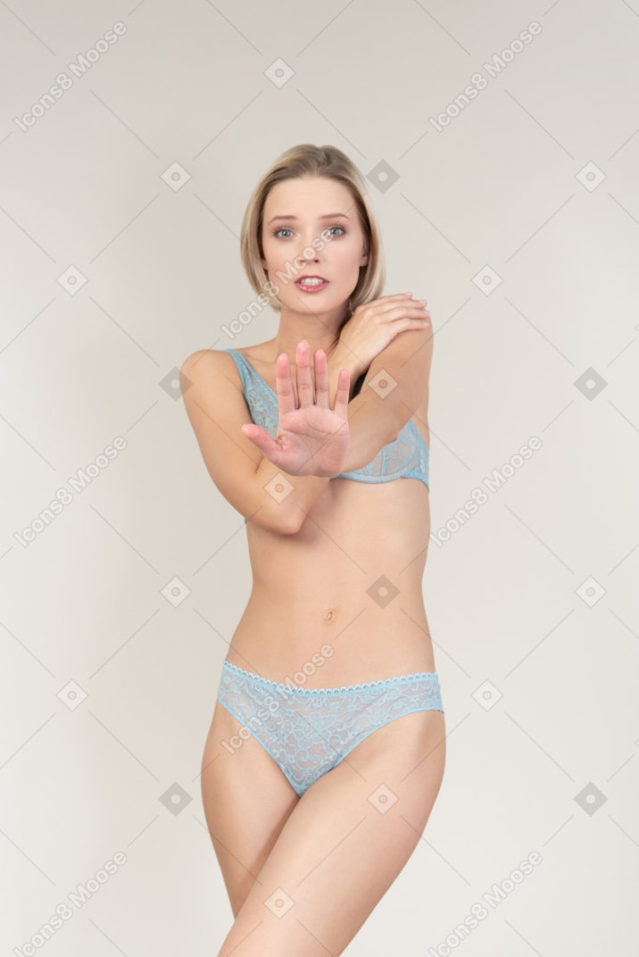 Young woman in lace lingerie closing herself with arms