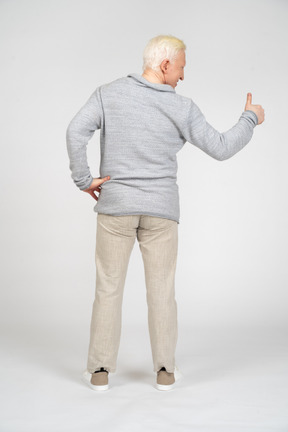 Rear view of man giving thumbs up