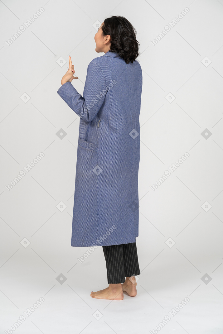 Retrovisione di una donna eccitata in un cappotto