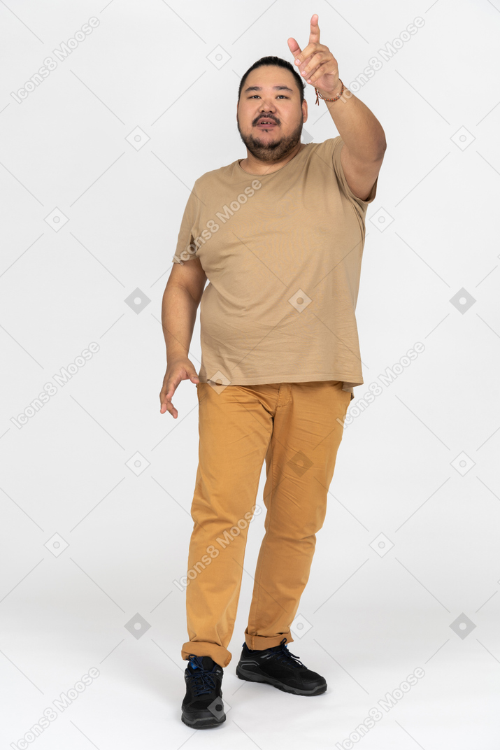 Black haired asian man pointing upwards