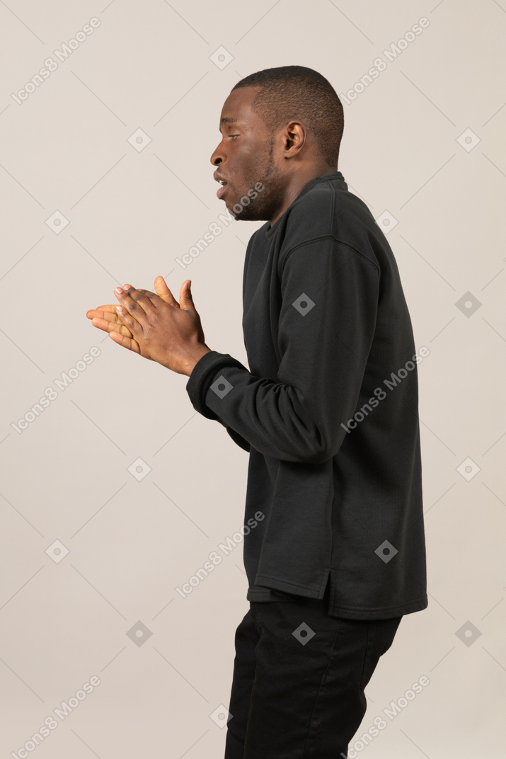 Side view of man rubbing his hands